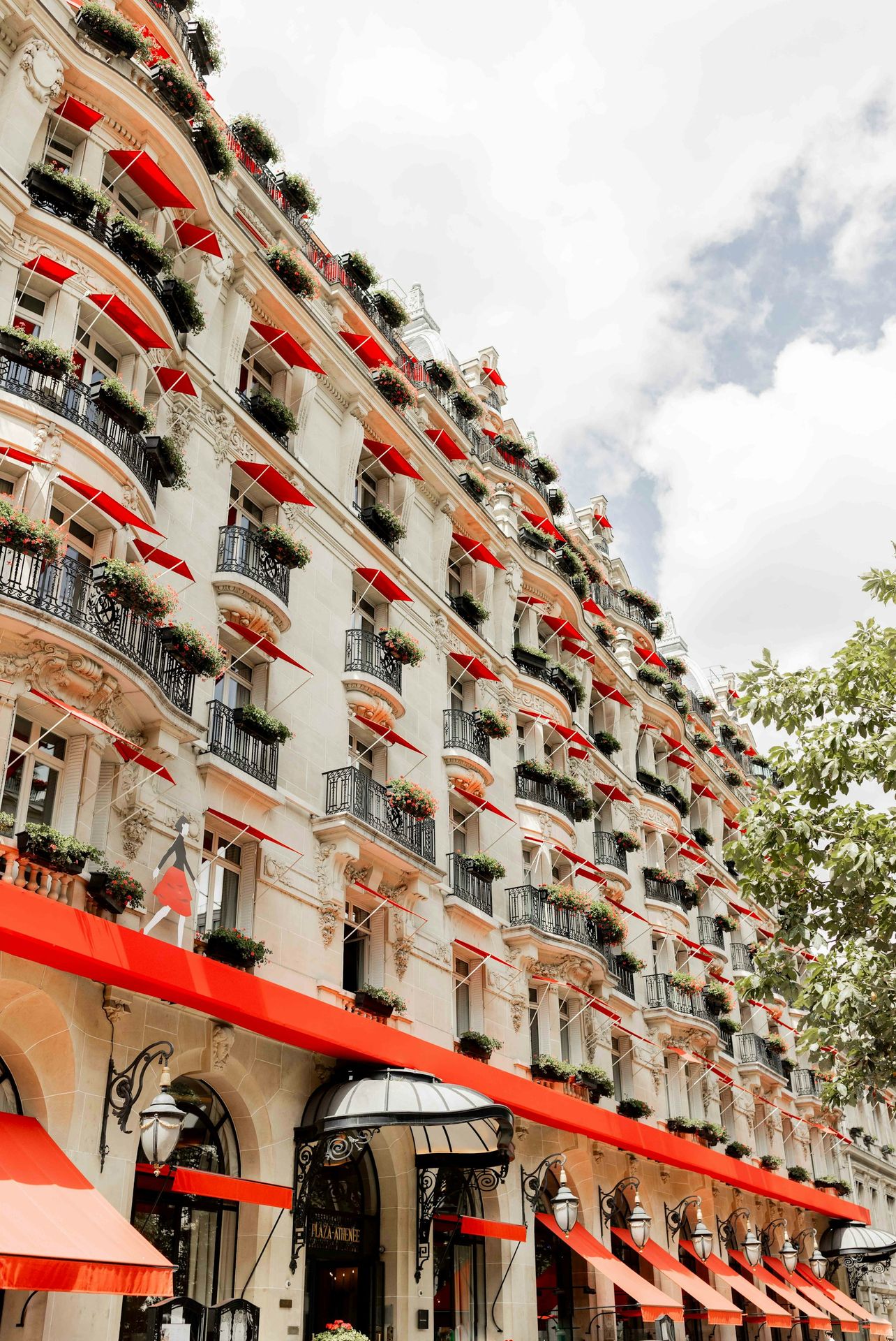 A very tall building with red awnings on the side of it